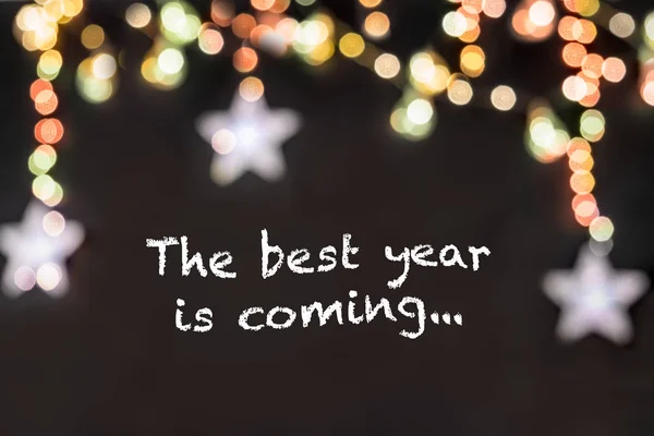 metin bulanık renkli yıldız ve ışık ile siyah arka plan en iyi yıl geliyor