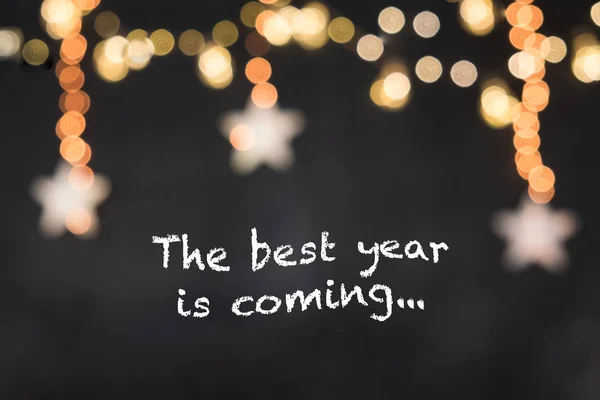 metin bulanık yıldız ve ışık ile siyah arka plan en iyi yıl geliyor