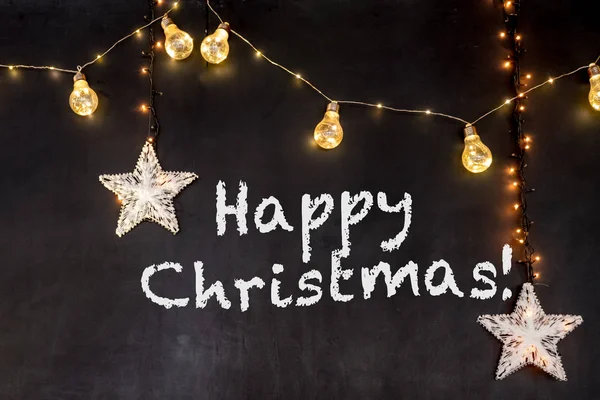 Mutlu Noel metin sarı lambaları ve yıldız ile siyah arka plan
