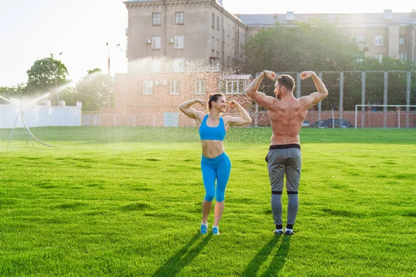 Homem mulher e jogando futebol no campo do estádio gramado e ambiente  natural em jogo de competição e desafio amigos de fitness esportistas e  jogadores de futebol em treinamento de bola de