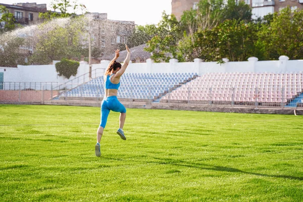 競技場では女性アスリートが宙返りをし 屋外で演習を行い 複雑なアクロバティックな演習を行う スポーツと健康的なライフスタイル 新鮮な一日の始まりとレクリエーション — ストック写真