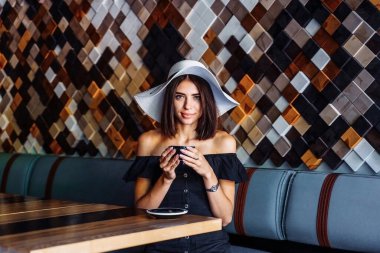 Şefkat ve sıcaklıkla bir fincan sıcak çay ya da kahve içen genç bir kadın. Boş bir kafede yapayalnız. Sıkılmış bir kadının melankolik sonbahar havası. Arkadaşlarını ve iletişimini bekliyor..