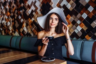 Şefkat ve sıcaklıkla bir fincan sıcak çay ya da kahve içen genç bir kadın. Boş bir kafede yapayalnız. Sıkılmış bir kadının melankolik sonbahar havası. Arkadaşlarını ve iletişimini bekliyor..