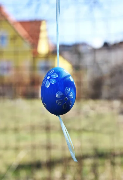 Painted egg hangs in a garden at easter holiday. — Stock Photo, Image