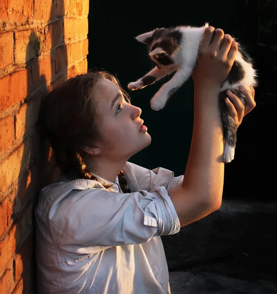 아름다운 소녀가 야외에서 흑백의 고양이를 올리고 있습니다 우정과 동물과 — 스톡 사진