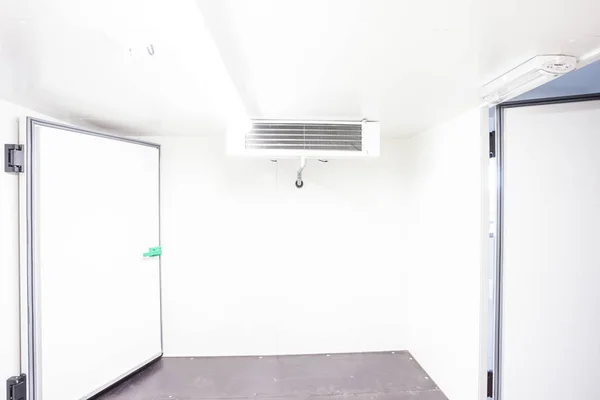 an empty industrial room refrigerator with four fans