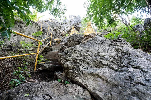 in nature in the north of Thailand there is a Buddha on a stone raised on the rocks of a high geberte