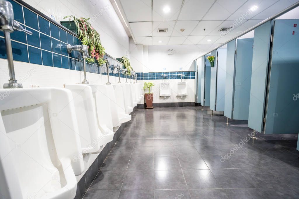 urinals and toilet doors in an old building for men only