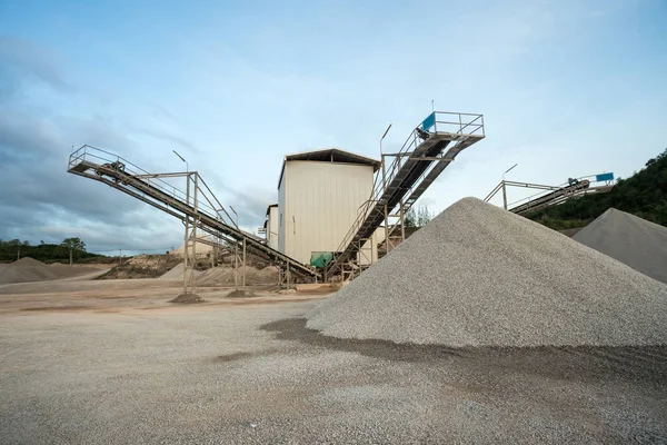 a mountain of sand lies in the concrete factory where and a conveyor belt for transporting the sand