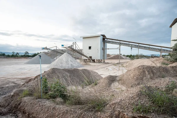 a mountain of sand lies in the concrete factory where and a conveyor belt for transporting the sand