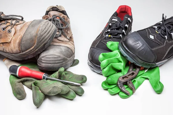 new work shoes and old work shoes with iron tips, new and old work gloves with a cross-screwdriver and a water wrench