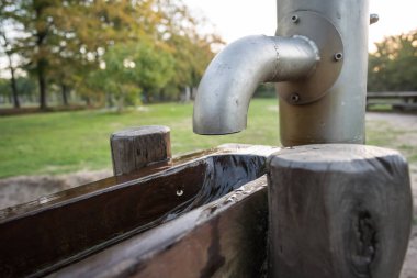 bir parkta bir su pompası ile ahşap bir şelale var