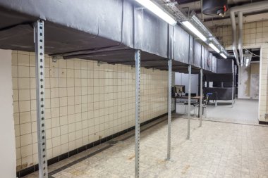 Büyük bir binanın bodrumundaki teknik bir odada uzun bir havalandırma borusu.