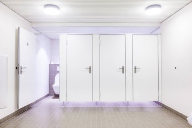 Genel bir binada womans tuvaletler katiyen beyaz kapı vardır.