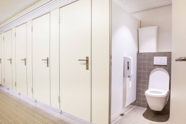 Genel bir binada womans tuvaletler katiyen beyaz kapı vardır.