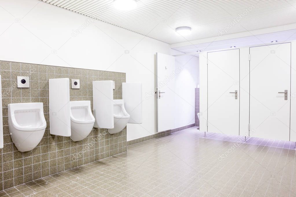 urinals and toilet doors in an old building for men only