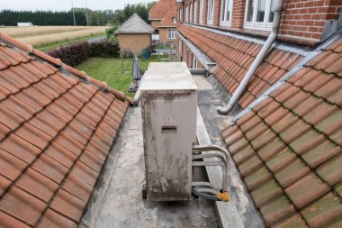 İki çatı arasındaki eski bir binada soğutma ünitesi var.