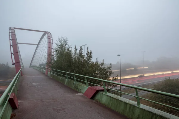 아침에 안개가 자욱하게 고속도로를 가로지르는 자전거 — 스톡 사진