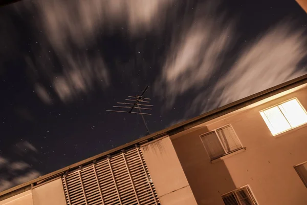 Langzeitbelichtungsaufnahme Weißer Wolken Die Nachts Über Dem Dach Eines Modernen — Stockfoto