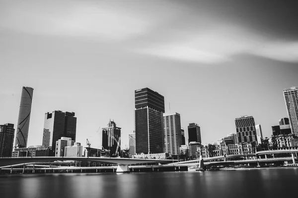 Back and white shot of calm river and modern bridges near skyscrapers of Brisbane, Australia