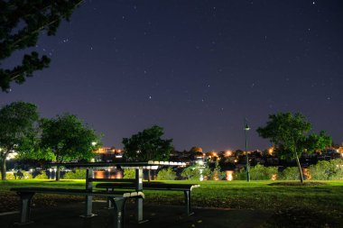 Ahşap masa ve şehir parkı Brisbane, Avustralya yıldızlı gece ayakta banklar