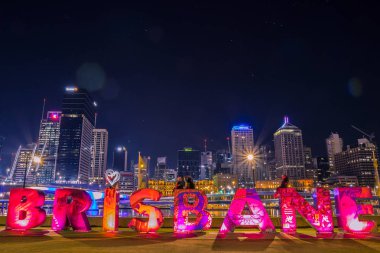Parlak ışıklı Brisbane muhteşem gece şehir Avustralya'da arka plan üzerinde ayakta yazma