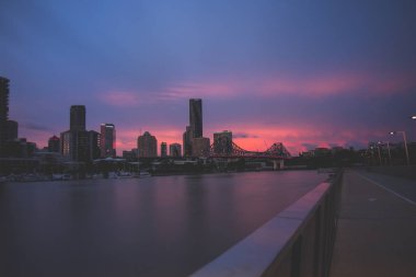 Ismarlayarak modern binalar ve sakin Nehri Köprüsü muhteşem akşam Brisbane, Avustralya