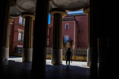 Tanınmayan erkek showplace antik dekore edilmiş sütunlarla ve binalar kırmızı tuğla ve çatı çit gündüz ile yürüyüş