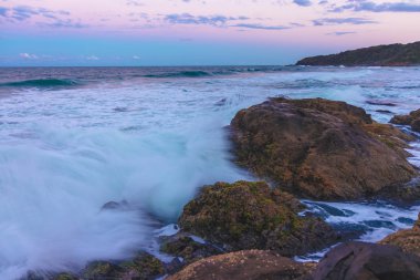 Byron Bay, Avustralya'da sunrise taş beach yakınındaki dalgalar deniz fırtınası ısmarlayarak