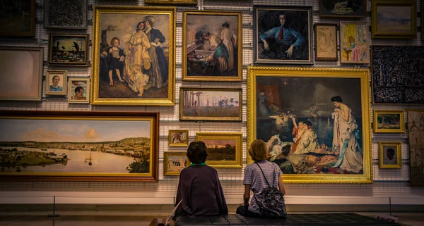 在澳大利亚布里斯班 坐在板凳上观看不同绘画的儿童的背部视图 — 图库照片