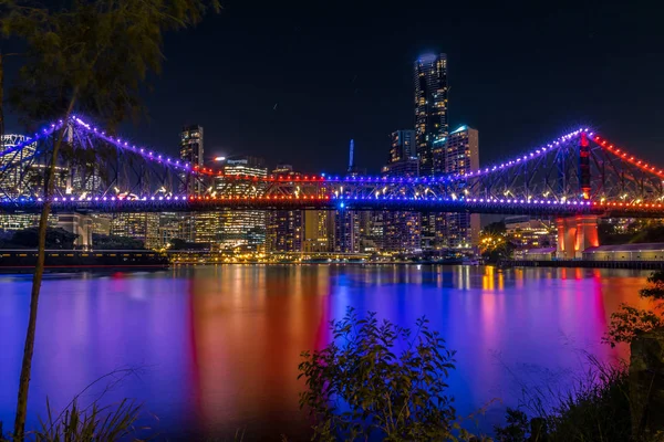 夜间水中反射的明亮的高层建筑和桥梁的外部视野 — 图库照片