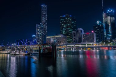 Sakin nehir suyu, Brisbane yansıtan gökdelenler ile modern şehir parlak neon ışıkları