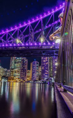 Su, Brisbane yansıtan arka plan üzerinde köprü ve gökdelenler ile parlak ışıklı set of görünümü