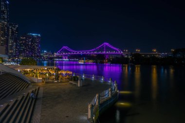 Seafront, Brisbane modern binalar ile gece zamanında nehir su üstünde parlak parlayan köprü görünümü
