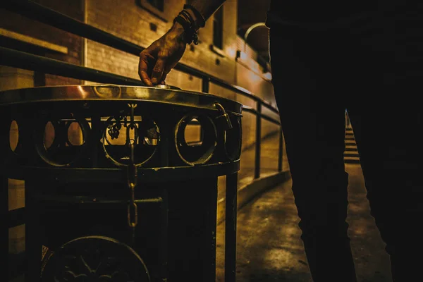不露面的匿名男子在街上研磨香烟在街上的金属垃圾桶 — 图库照片