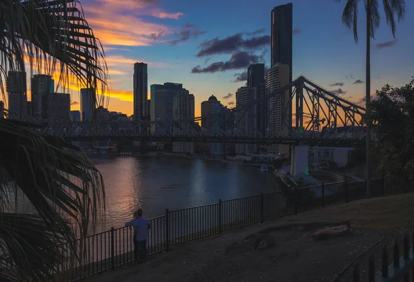 匿名年轻夫妇站在栏杆附近的平静河流和现代城市在布里斯班 澳大利亚的背景下 — 图库照片