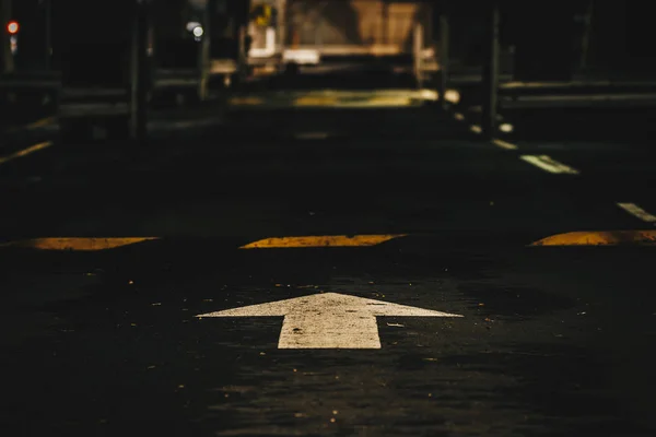 White arrow pointing forward painted on asphalt path in Brisbane, Australia