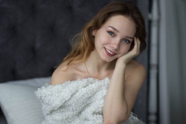 yatak yatak odasında sabah oturan genç kadın