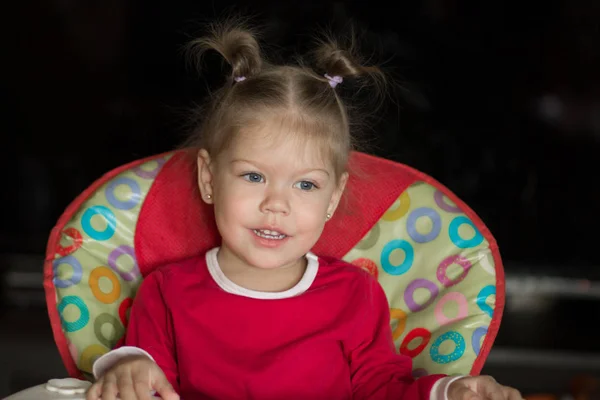 Retrato de niña con mirada pensativa y sonriente sentada en la silla —  Fotos de Stock