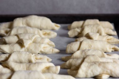 tepsi üzerinde döşeme pişirme için ham haddelenmiş kruvasanlar