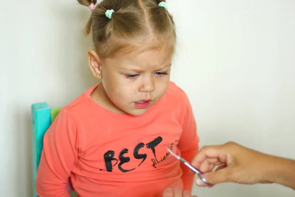 Petite fille apeurée de couper les ongles par des ciseaux de manucure — Photo