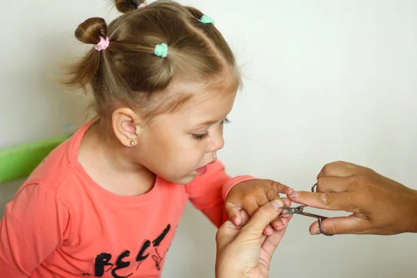 Sevimli küçük kız manikür makas ile tırnaklarını kırpma bakıyor