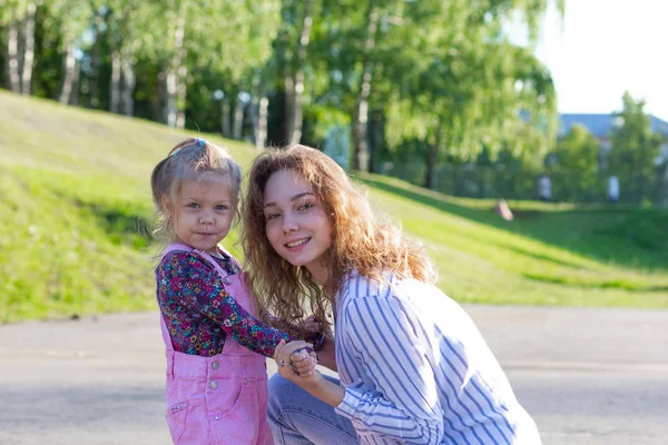 Junges Mädchen hält Hände mit lächelndem und schönem Kind und blickt in die Kamera — Stockfoto