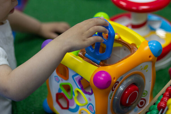 Little girl playing with toy cube in game room
