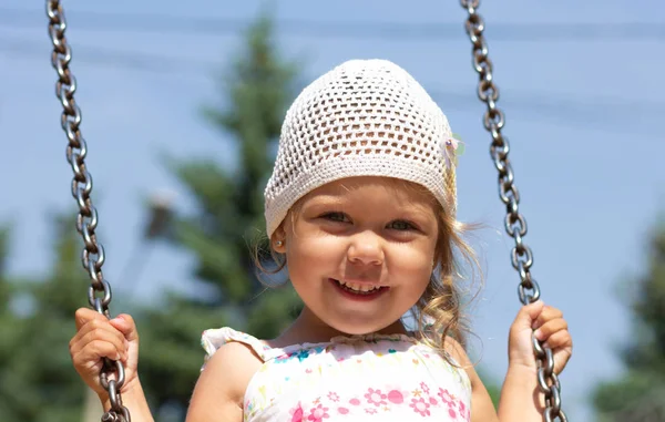 Sonriente niña feliz balanceándose en el parque de verano —  Fotos de Stock