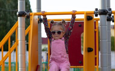 Oyun alanında güneş gözlüğü küçük kız