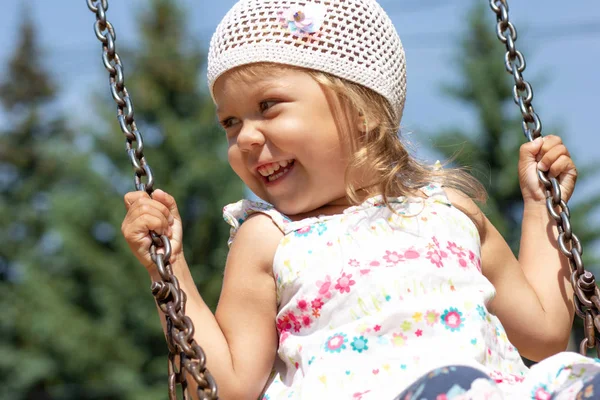 Sonriente niña feliz balanceándose en el parque de verano —  Fotos de Stock