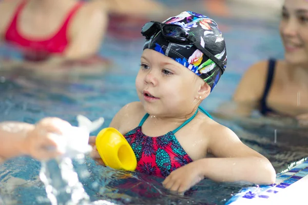 Little girl with goggles in the swimming pool — Stock Photo, Image