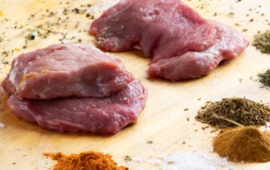 Baharatlı ahşap masada çiğ pişmemiş et dilimleri