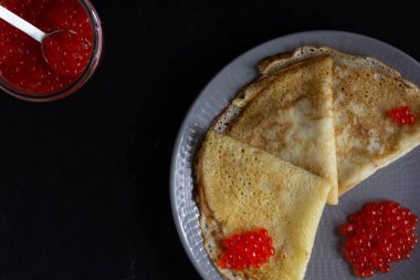 Blini üçgenler veya krep kavanoz ile plaka üzerinde kırmızı havyar ile